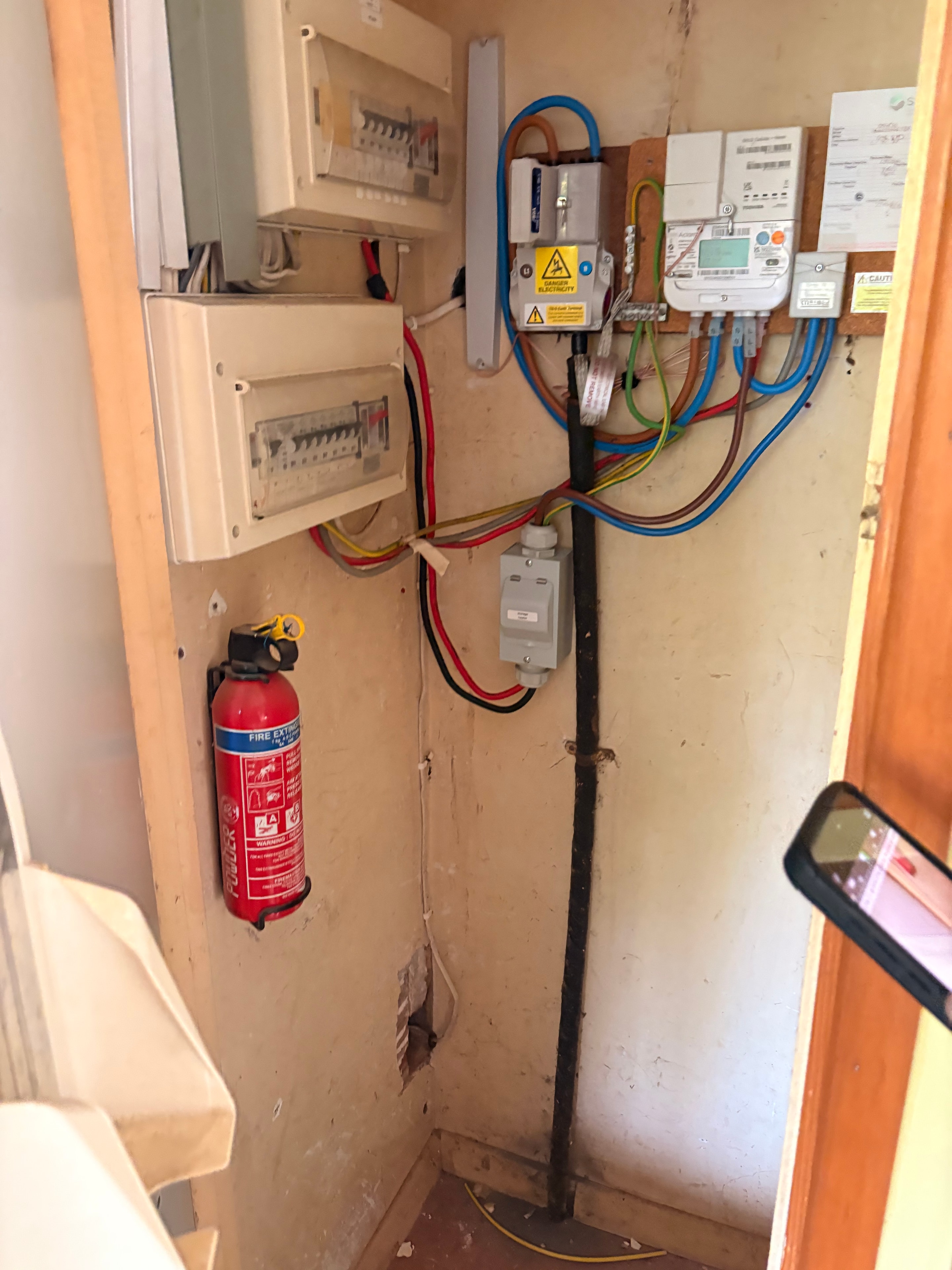 Meter cupboard showing new consumer unit, meter tails and supply-side wiring for the Goodmayes storage heater installation
