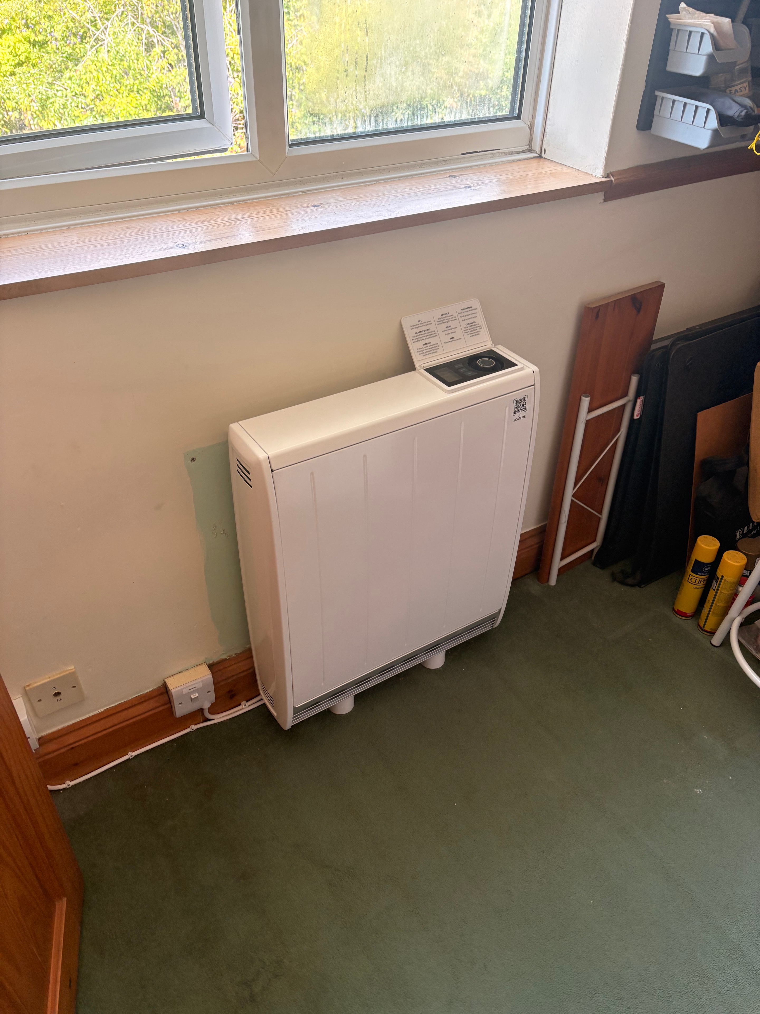 Completed storage heater on living room wall by window — Goodmayes government grant installation