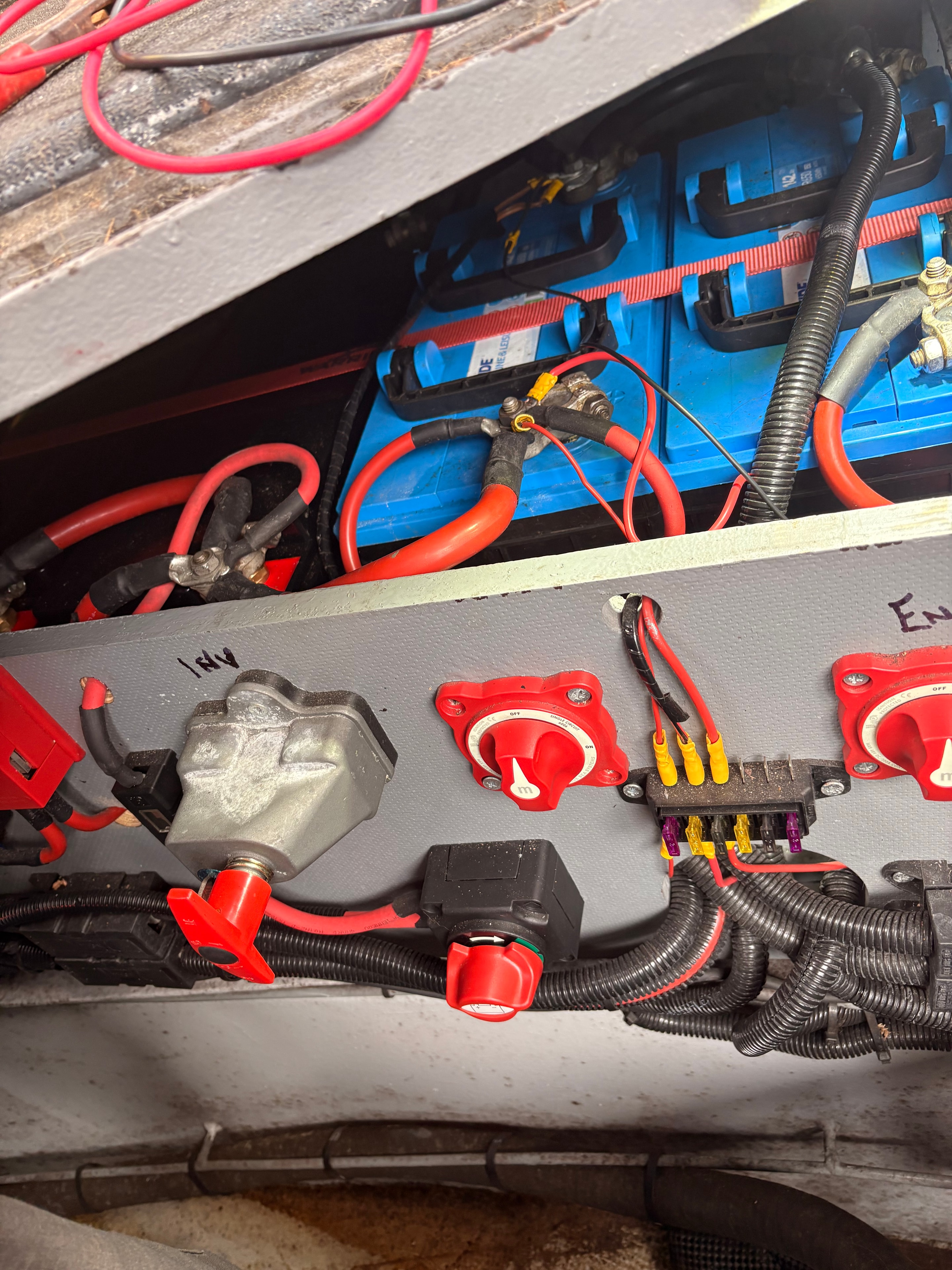 Battery compartment on boat at Thames Ditton marina showing battery bank, wiring and the faulty isolator switch before replacement
