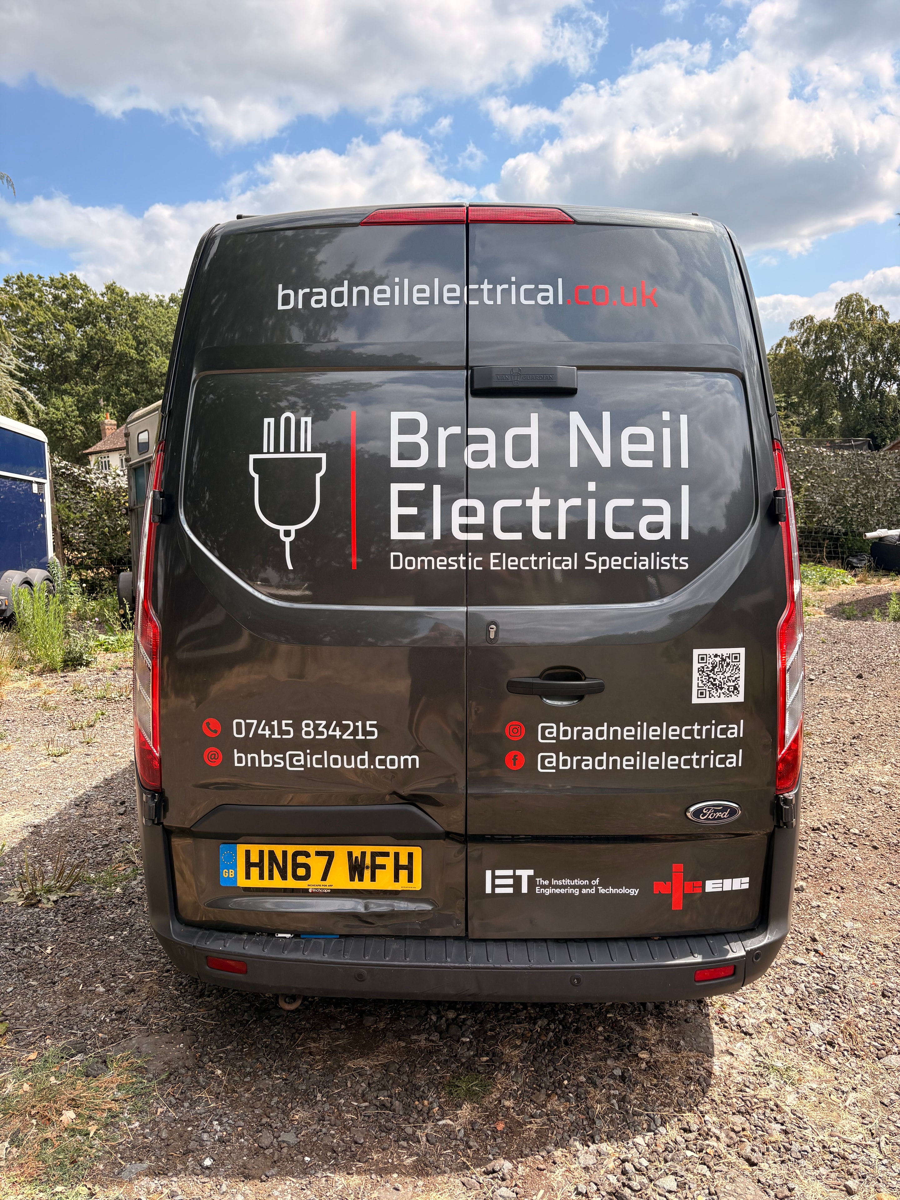 Brad Neil Electrical van — rear doors showing full logo, plug icon, contact details, QR code and IET and NICEIC accreditation logos