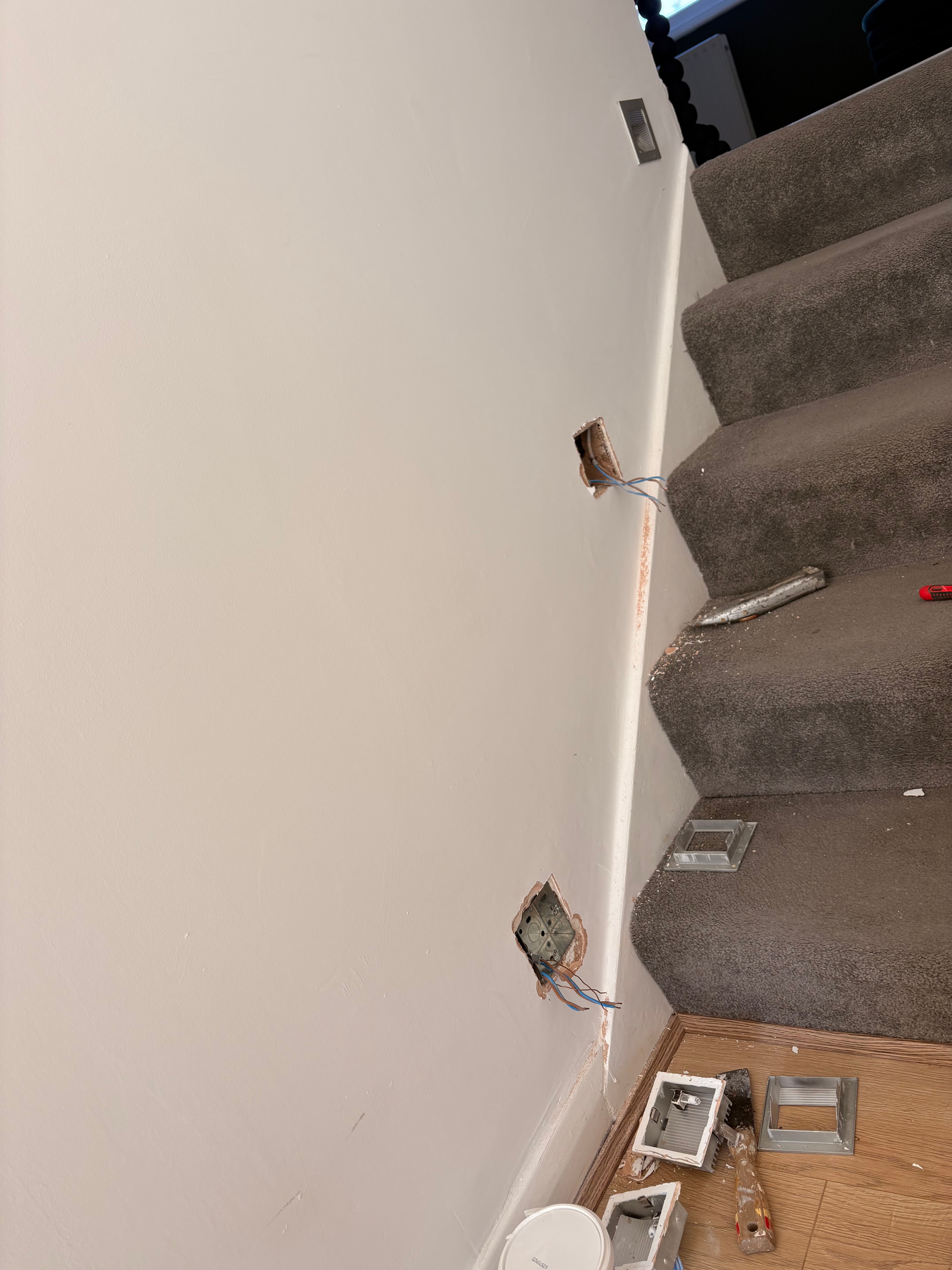 Mid-installation showing flush boxes and new fittings being positioned on the staircase